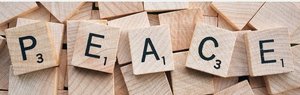 Das Wort PEACE ist mit Scrabble-steinen dargestellt