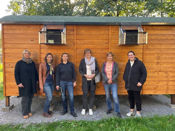 Mehrere Personen vor einem Holzhäuschen