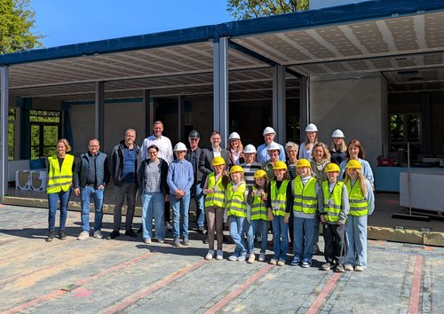 Gruppenbild: Erwachsene und Kinder mit gelben Warnwesten 