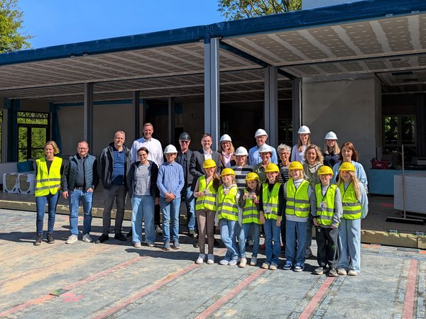 Gruppenbild: Erwachsene und Kinder mit gelben Warnwesten 