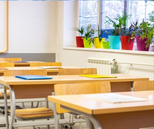 Tische und Stühle in einer Schulklasse