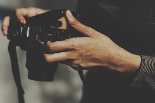 Person hält eine Kamera in den Händen