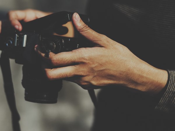 Person hält eine Kamera in den Händen