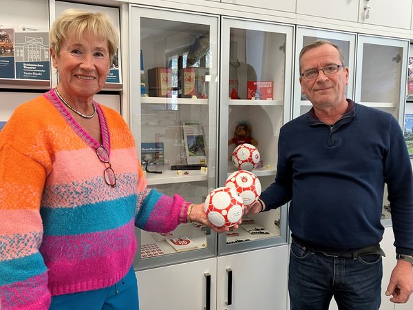 Zwei Personen vor einer Vitrine mit dem neuen Ball