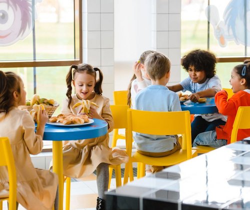 Schulkinder sitzen beim Mittagessen