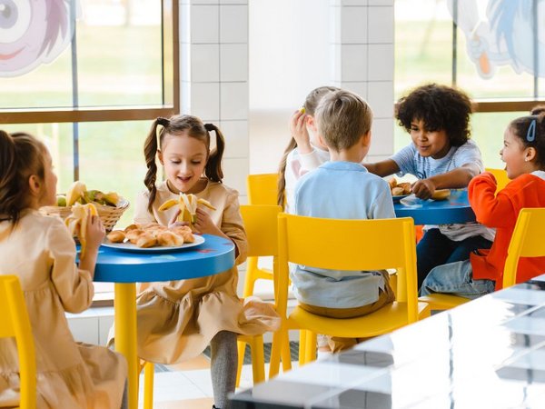Schulkinder sitzen beim Mittagessen