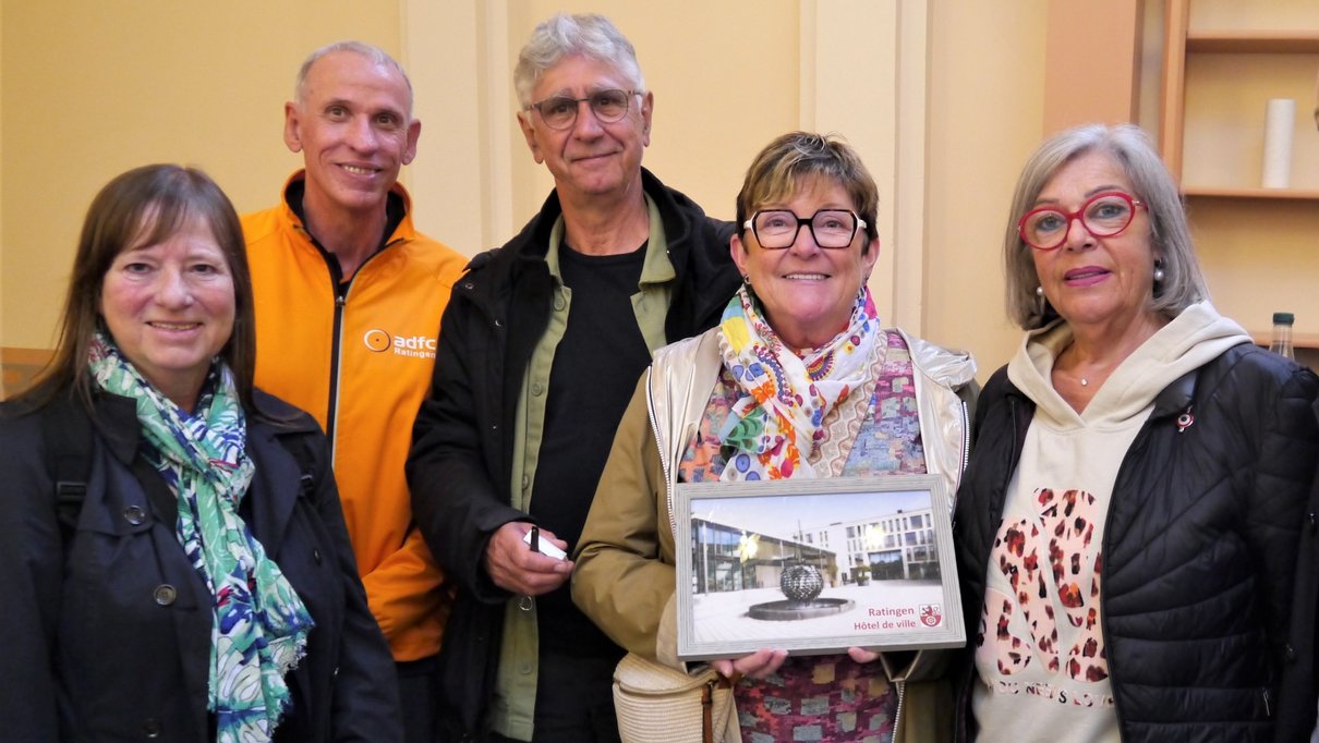 Gruppenfoto, eine Frau hält ein gerahmtes Foto in der Hand