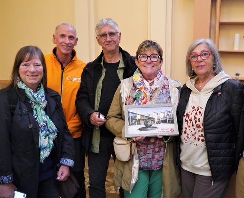 Gruppenfoto, eine Frau hält ein gerahmtes Foto in der Hand