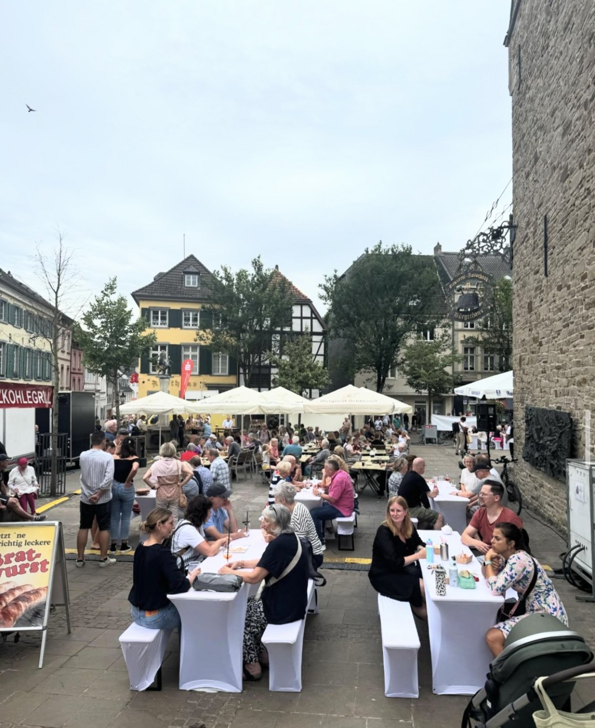 Festlich gedeckte Tische mit Menschen auf dem Marktplatz.