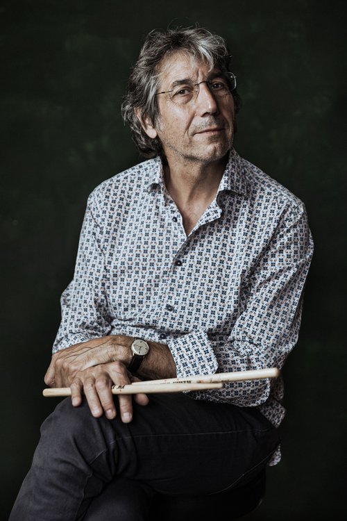 Sitzender Mann mit Schlagzeugstöcken in der Hand