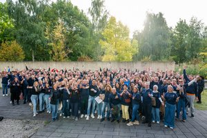 ungefähr 300 Mitarbeitende von DKV Mobility jubeln beim Community Day in Ratingen