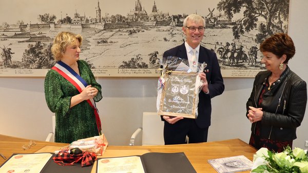 Bürgermeisterin Marie-Sophie Lesne und der Vorsitzenden des Komitees für kulturellen Austausch, Marie-Christine Depelsenair überreichen Bürgernmeister Klaus Pesch ihr Gastgeschenk