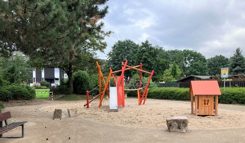 Spielplatz mit Spielhaus und  Turm im Sand