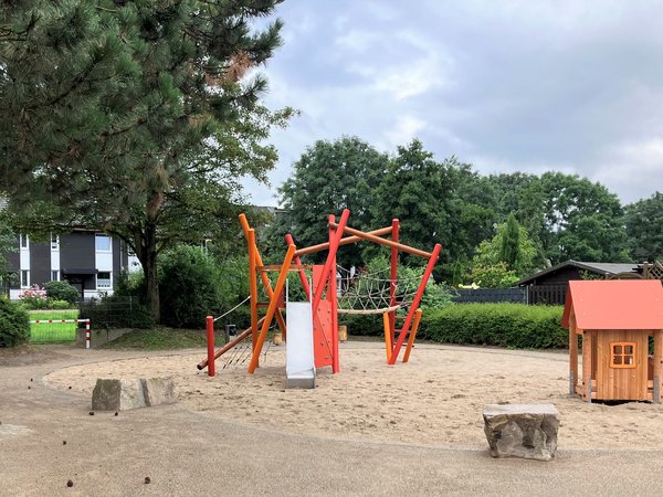 Spielplatz mit Spielhaus und  Turm im Sand