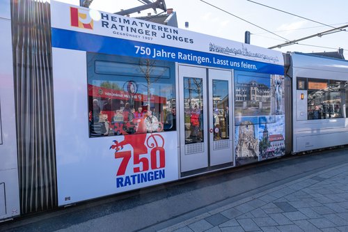 Teil einer Straßenbahn mit Werbung für das Ratinger Stadtjubiläum beklebt