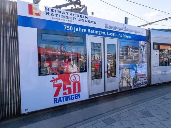 Teil einer Straßenbahn mit Werbung für das Ratinger Stadtjubiläum beklebt
