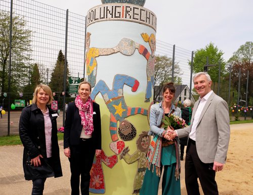 Vier Personen an einer Mosaik-Litfaßsäule