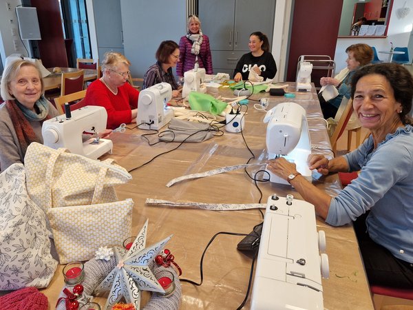 Mehrere Frauen sitzen an einer Nähmaschine