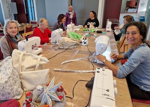 Mehrere Frauen sitzen an einer Nähmaschine