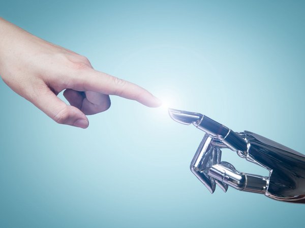 Mensch und Roboter berühren sich am Finger