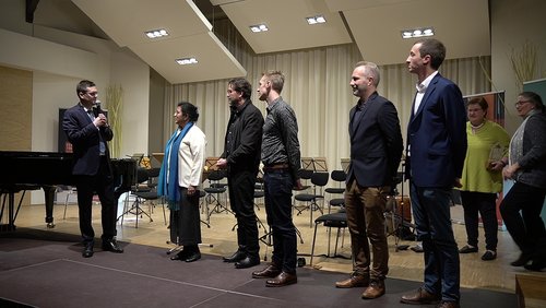 Mehrere Personen stehen nebeneinander auf einer Bühne 