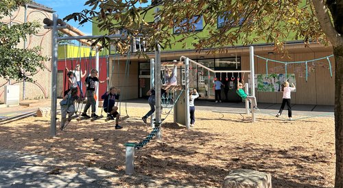 Kinder spielen auf Anlage mit Geschicklichkeitsstationen