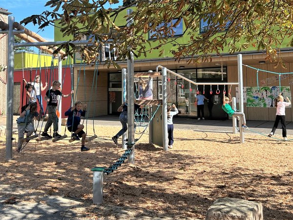 Kinder spielen auf Anlage mit Geschicklichkeitsstationen