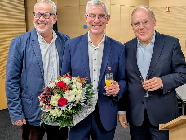 Drei Männer mit Blumenstrauß