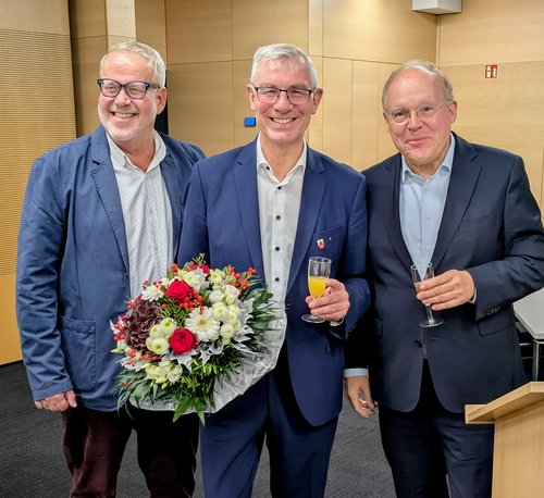 Drei Männer mit Blumenstrauß