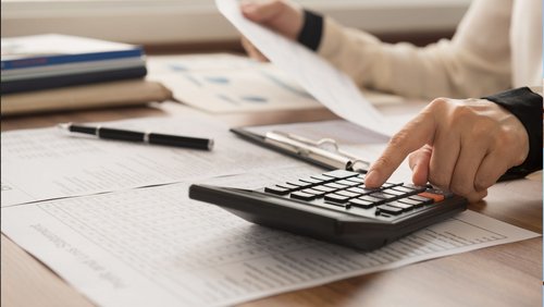 Finger tippt auf einem Taschenrechner