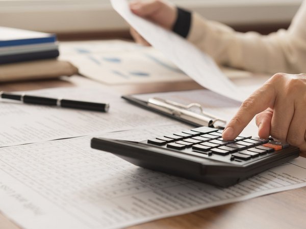 Finger tippt auf einem Taschenrechner