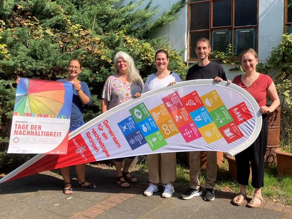 Fünf Personen halten Plakate und Werbesegel in den Händen