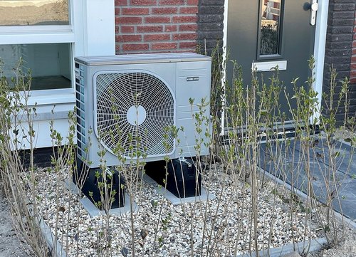 Wärmepumpe vor einem Hauseingang
