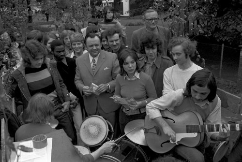 Größere Menschenmenge, im Vordergrund ein Mann mit Gitarre