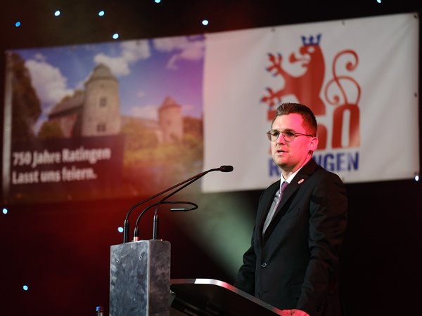 Mann steht am Rednerpult