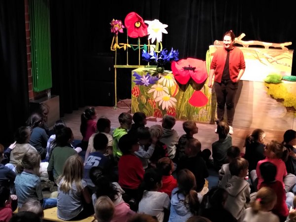 Kinder beobachten eine Theaterszene auf der Bühne