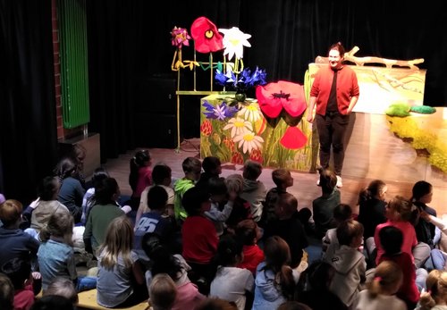 Kinder beobachten eine Theaterszene auf der Bühne