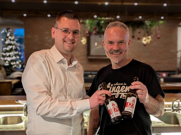 Zwei Männer stoßen mit Bierflaschen an