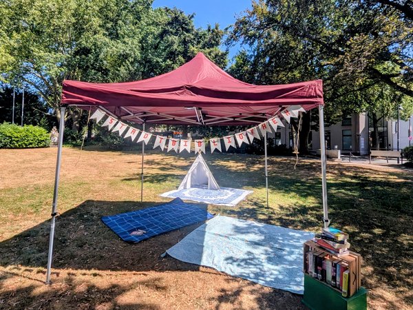 Ein Pavillon mit einer Decke darunter in einer Grünfläche 