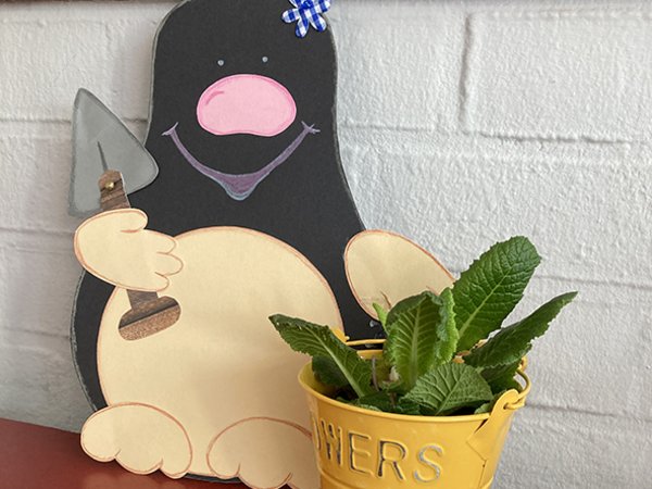 Maulwurf als Pappfigur mit einem Blumentopf