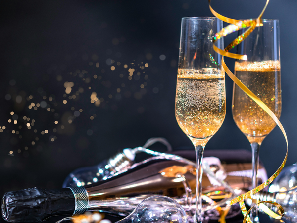 Zwei gefüllte Sektgläser, daneben liegt eine Flasche Sekt