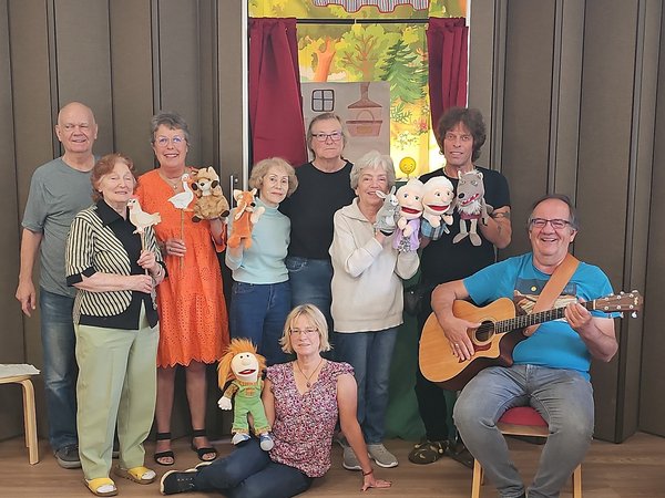 Mehrere Personen mit Gitarre und Handpuppen