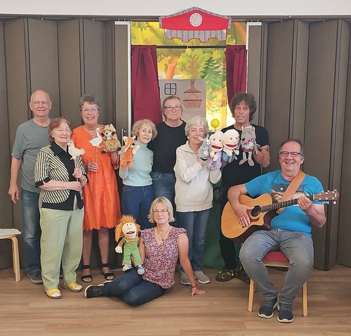 Mehrere Personen mit Gitarre und Handpuppen