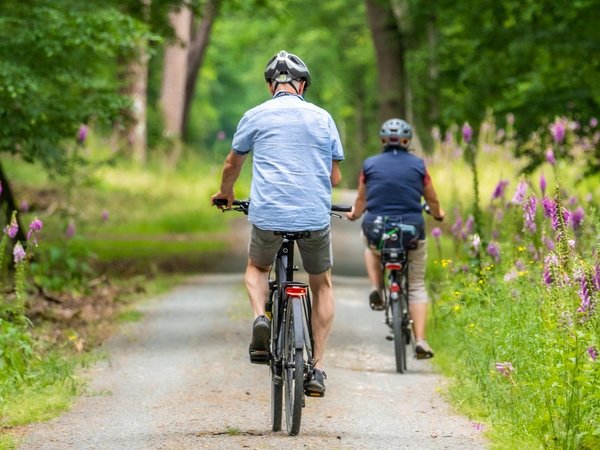 Mann und Frau radeln im Grünen