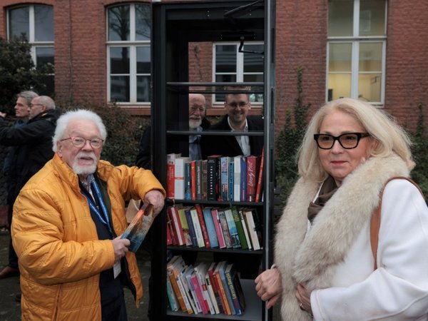 Zwei Personen vor einem Bücherschrank
