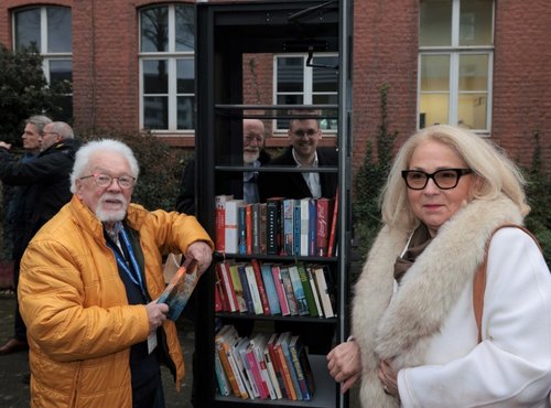 Zwei Personen vor einem Bücherschrank
