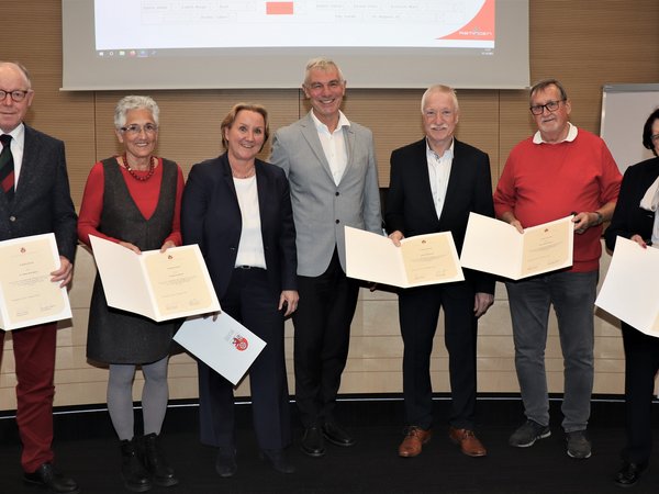 Gruppe von Menschen mit Urkunden in der Hand