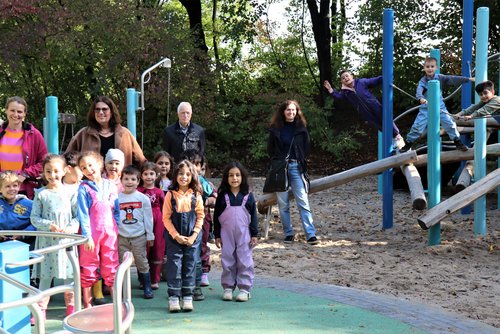 Kinder und Erwachsene vor einem Klettergerüst auf einem Spielplatz