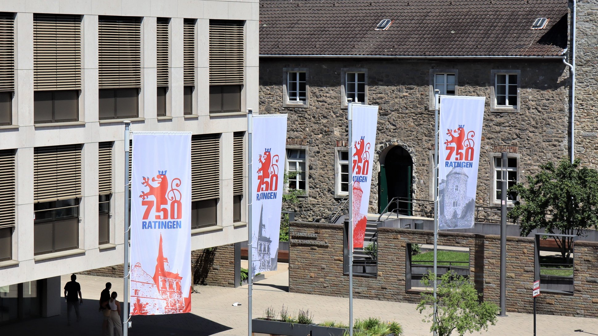 Vier Flaggen mit dem Jubiläumslogo wehen vor dem Rathaus der Stadt Ratingen