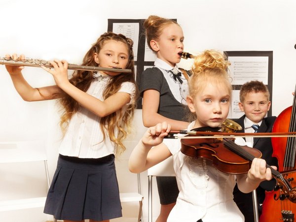 Kinder spielen verschiedene Musikinstrumente